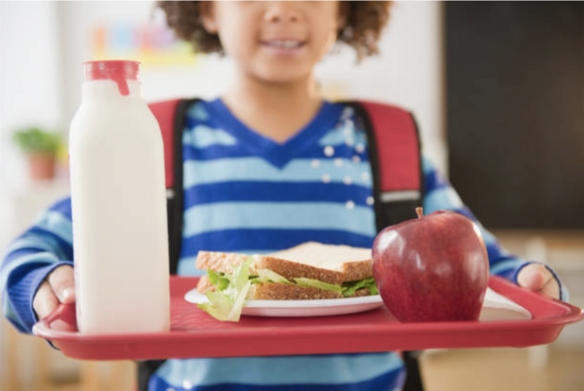 child with full school lunch tray