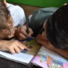students reading book together