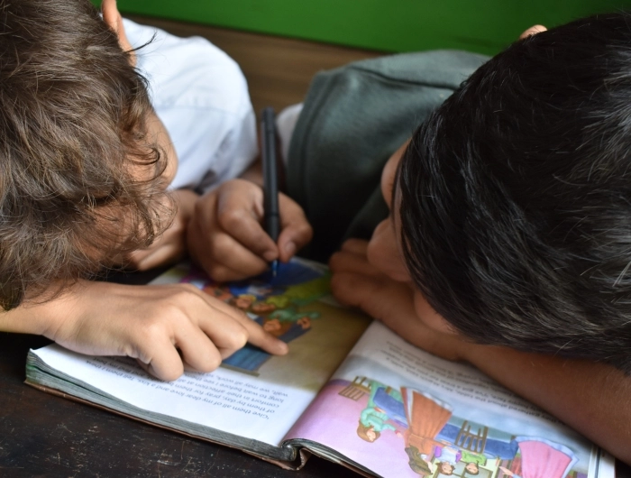 students reading book together